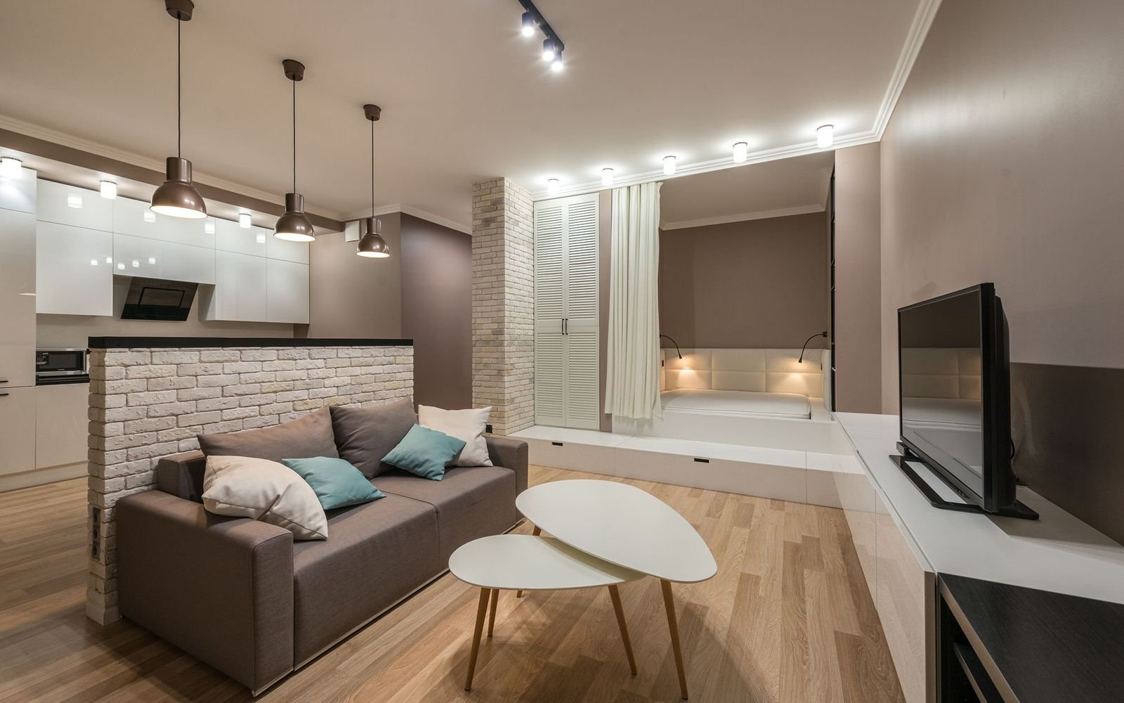 Living room with a sofa, coffee tables and a painted brick wall