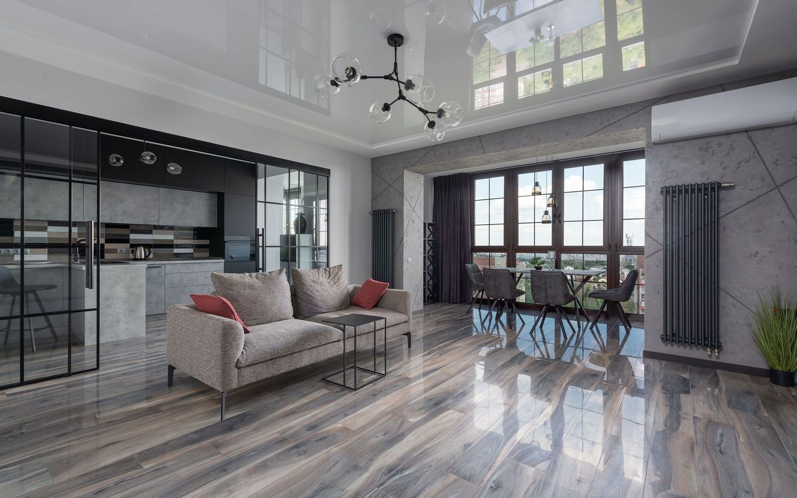Living room with glossy floors, a glass partition and city windows in a well maintained apartment