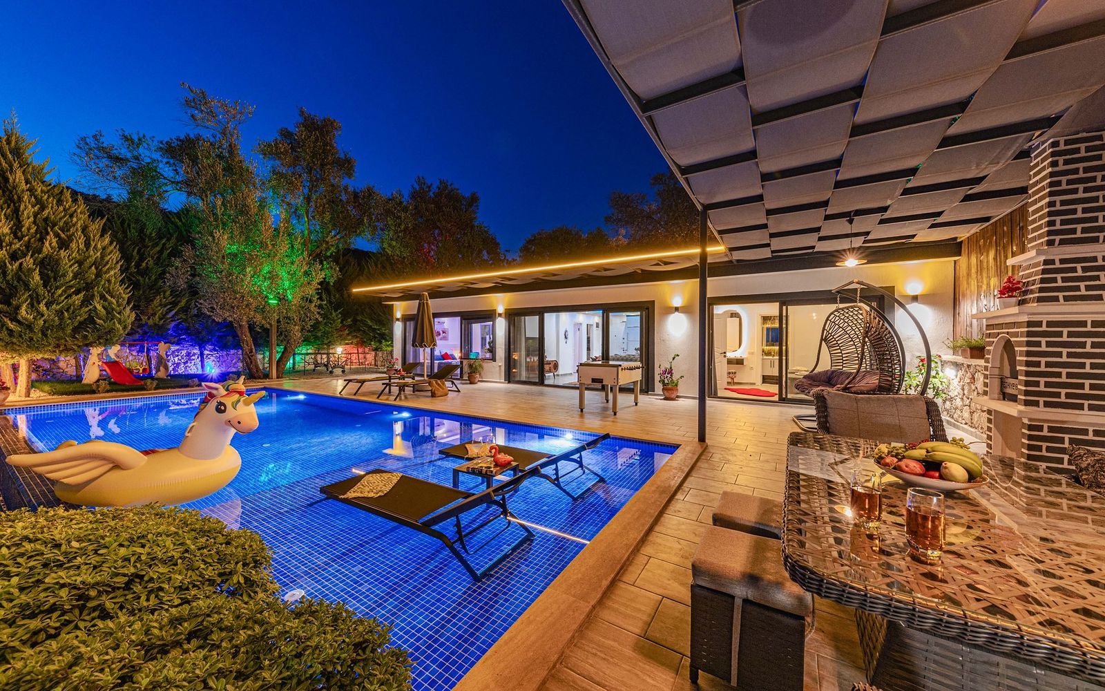 Villa with a glowing swimming pool in the evening, part of villa and pool area maintenance